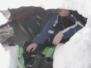 Backpacker in snow cave