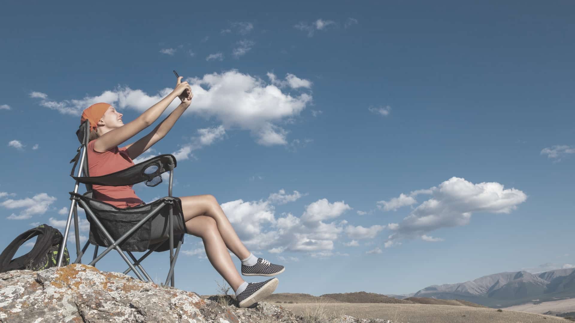 Women sitting on backpacking chair_FeatImage